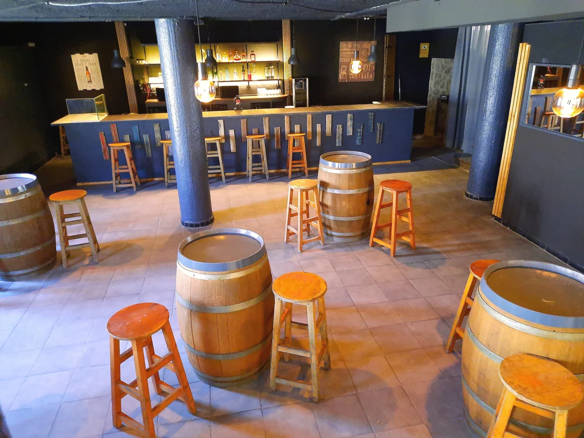 Zona de bar con barricas y taburetes del salón Ca Nostra